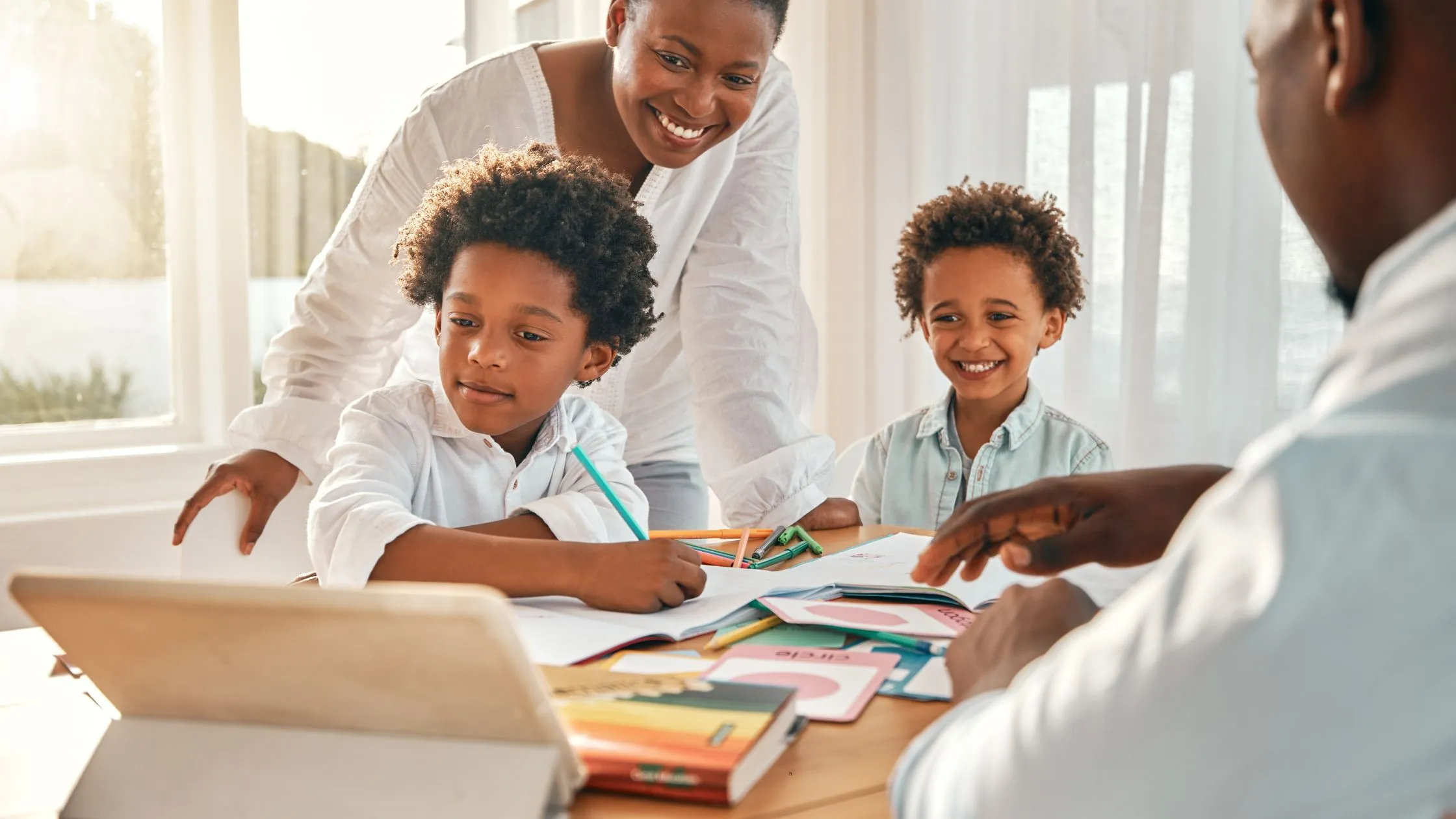 Parents reading with children around a table, reflecting family support for student success